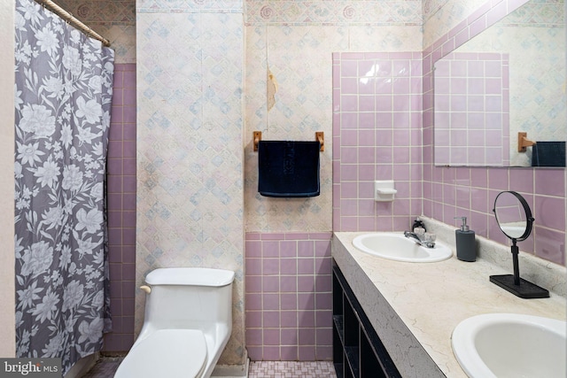 bathroom featuring a shower with shower curtain, vanity, toilet, and tile walls