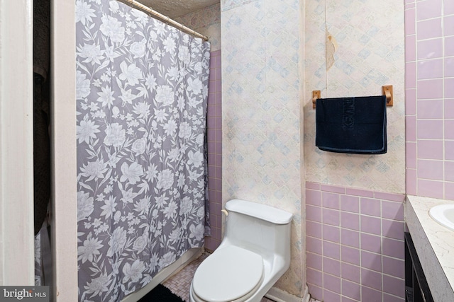 bathroom featuring vanity, toilet, tile walls, and curtained shower