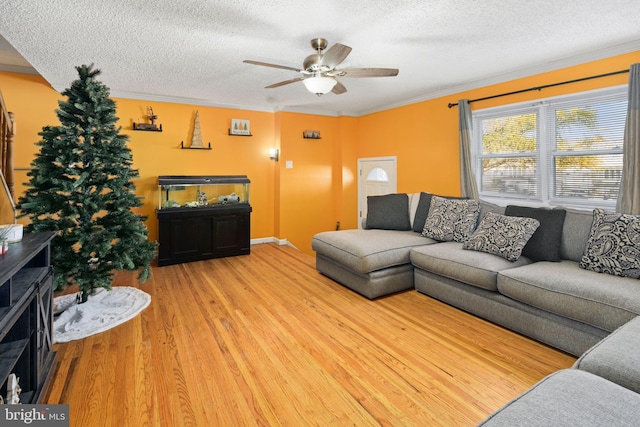 living room featuring a textured ceiling, hardwood / wood-style flooring, ceiling fan, and crown molding