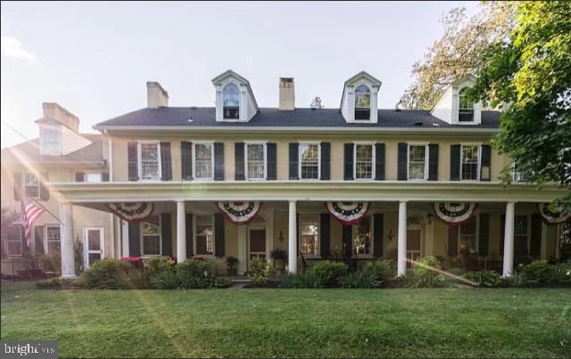 rear view of house with a yard and covered porch