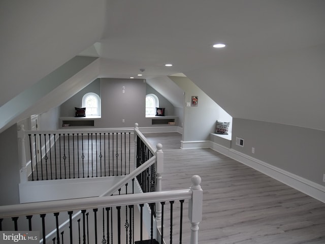 bonus room with vaulted ceiling and light hardwood / wood-style flooring