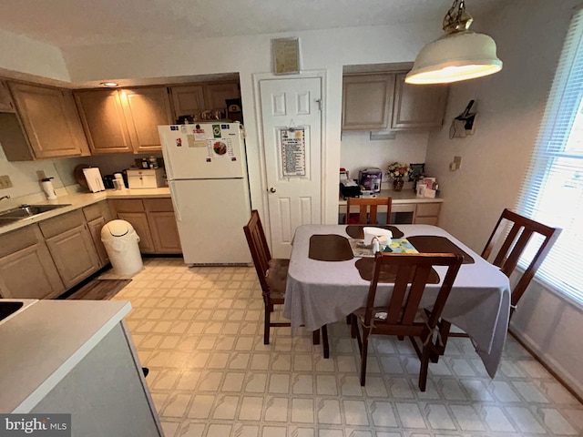 kitchen with sink, pendant lighting, and white refrigerator