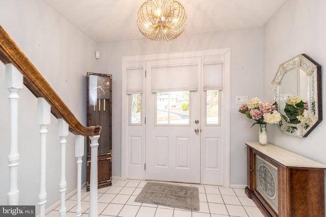 entrance foyer featuring baseboards, light tile patterned floors, an inviting chandelier, and stairs