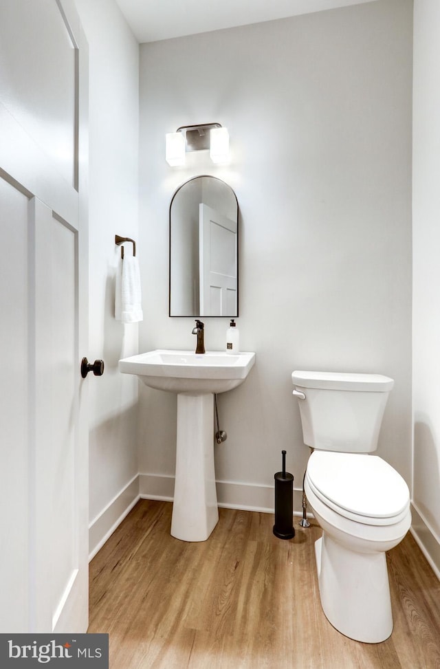 bathroom featuring hardwood / wood-style flooring and toilet