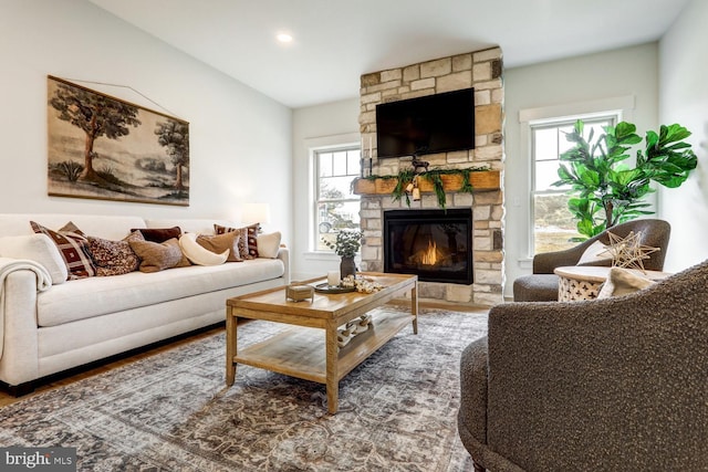 living room featuring hardwood / wood-style flooring and a stone fireplace