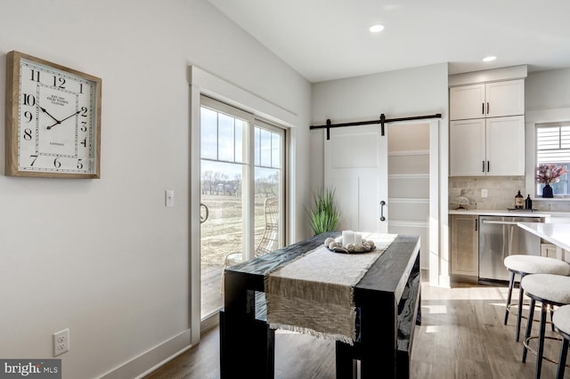 dining room featuring a barn door and light wood-type flooring