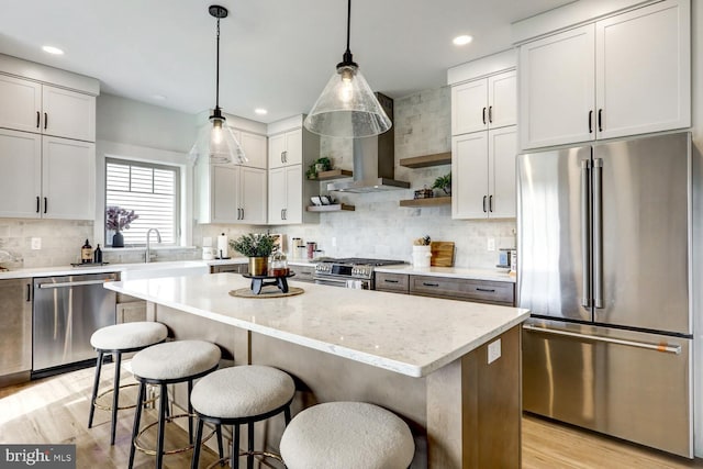 kitchen with high end appliances, a kitchen island, and pendant lighting