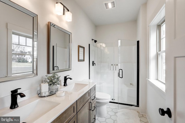 bathroom with a shower with door, vanity, and toilet