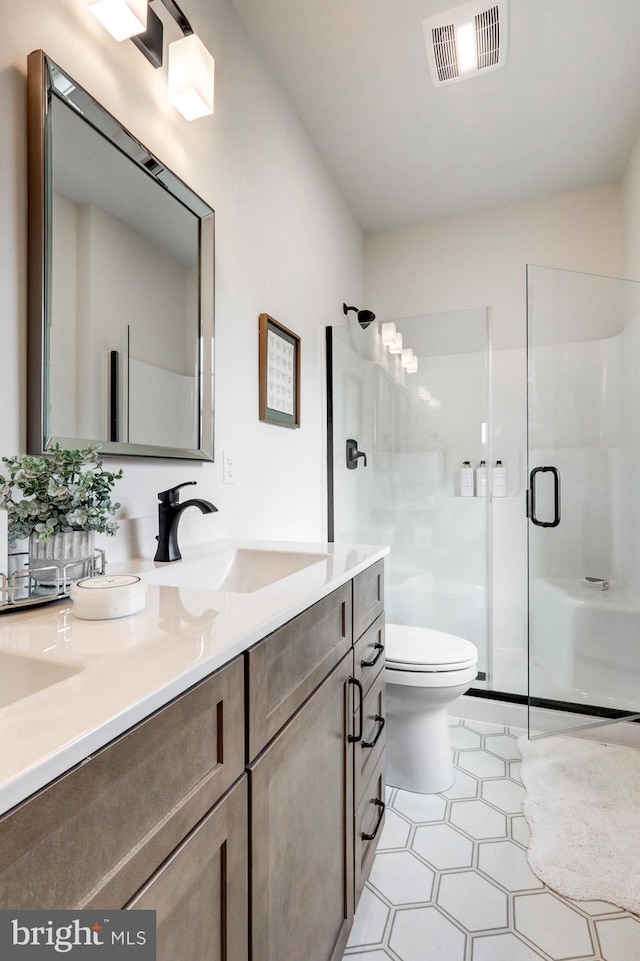 bathroom with toilet, vanity, and walk in shower