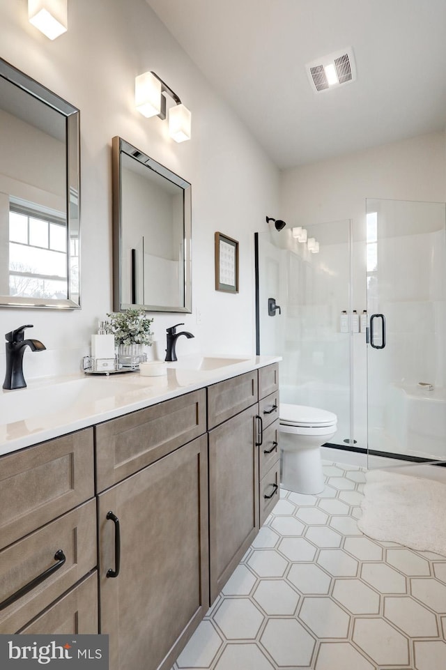 bathroom featuring walk in shower, vanity, and toilet