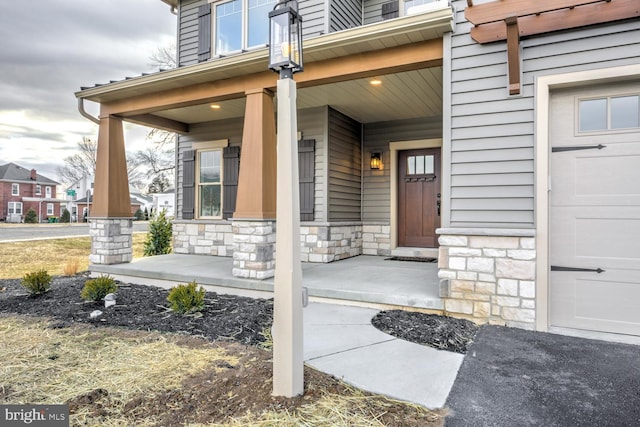 doorway to property with a porch and a garage