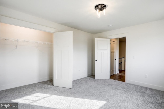 unfurnished bedroom featuring dark colored carpet and a closet