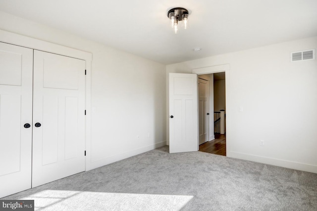 unfurnished bedroom with dark carpet and a closet