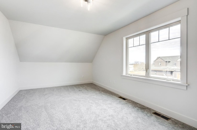 bonus room featuring vaulted ceiling and carpet