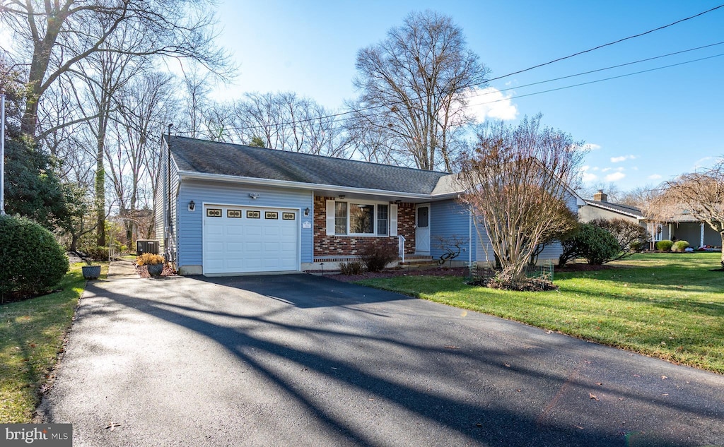 ranch-style home with a garage and a front lawn