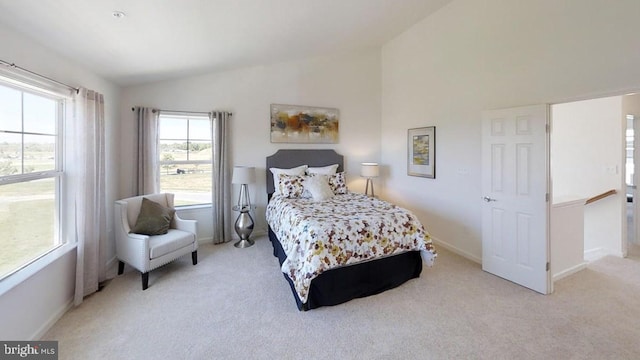 bedroom with light colored carpet and vaulted ceiling