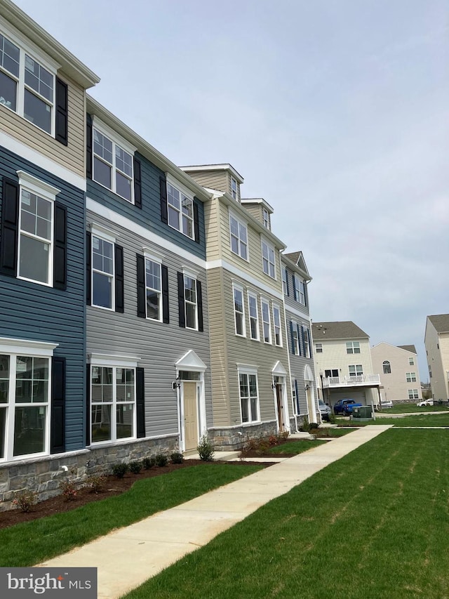 townhome / multi-family property featuring a front lawn