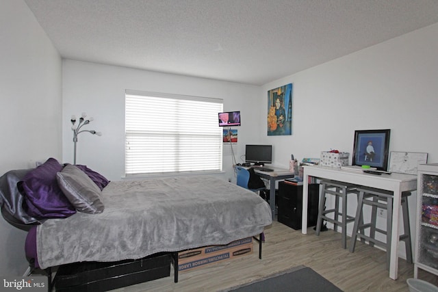 bedroom featuring hardwood / wood-style flooring and a textured ceiling