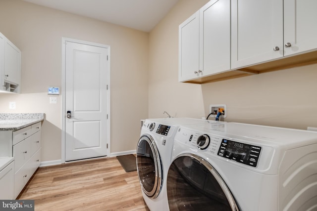 washroom with cabinets, separate washer and dryer, and light hardwood / wood-style flooring