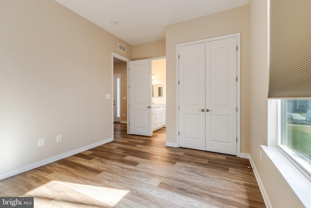 unfurnished bedroom featuring light wood-type flooring and a closet