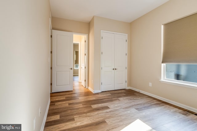 unfurnished bedroom featuring light wood-type flooring and a closet