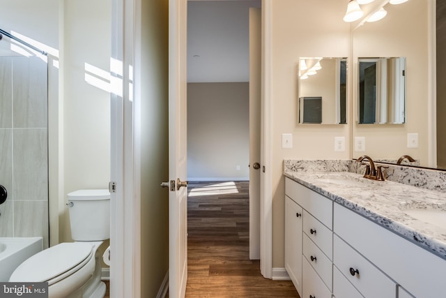 full bathroom with wood-type flooring, vanity, toilet, and shower / washtub combination