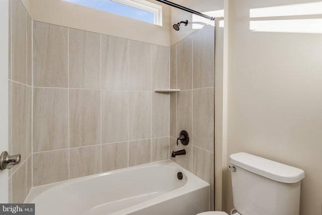 bathroom with tiled shower / bath combo and toilet