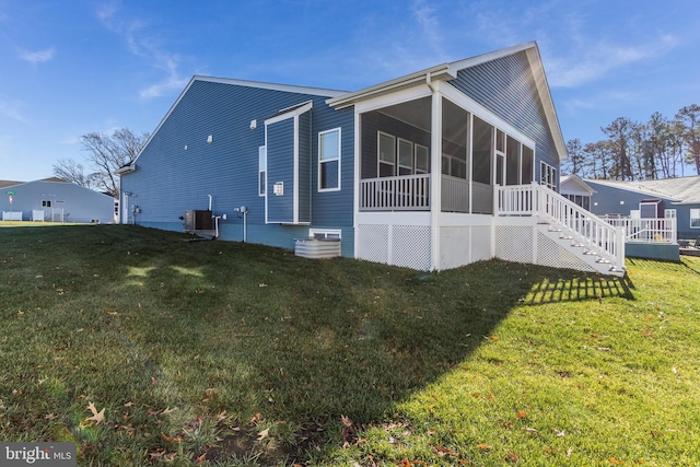 view of side of property with a sunroom, a lawn, and central AC