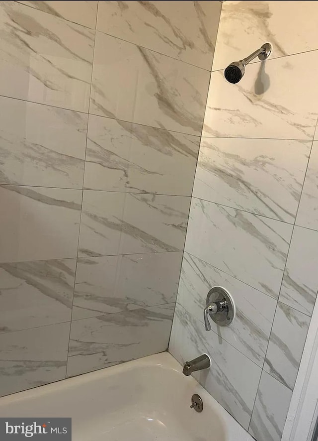 bathroom with tiled shower / bath combo