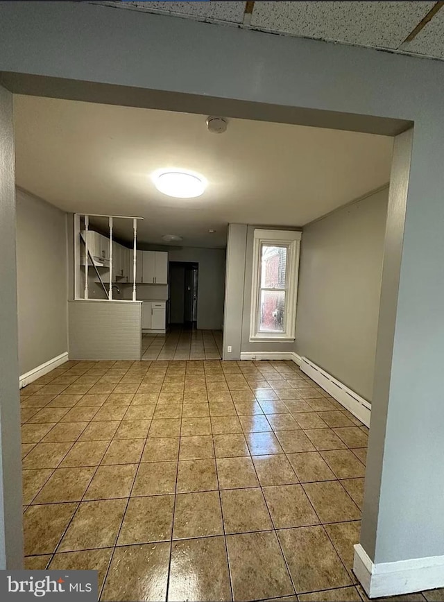 unfurnished room featuring light tile patterned floors and baseboard heating