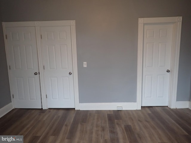 unfurnished bedroom with a closet and dark hardwood / wood-style floors