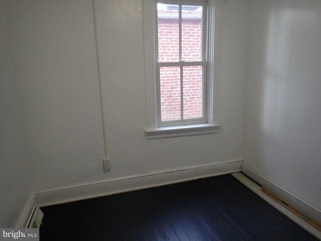 spare room with wood-type flooring and a healthy amount of sunlight