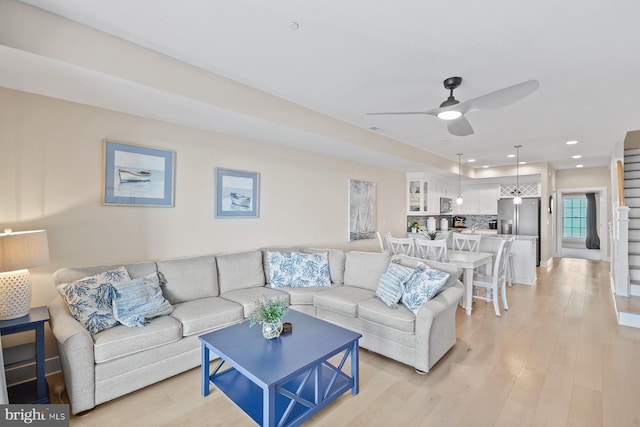 living room with light hardwood / wood-style floors and ceiling fan