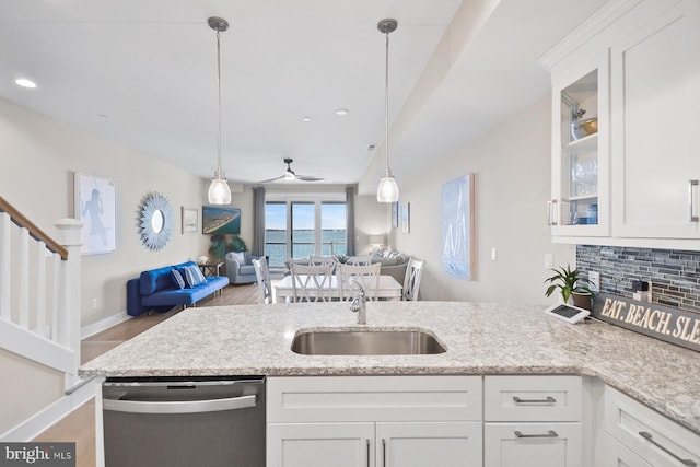 kitchen featuring dishwasher, ceiling fan, light stone countertops, and white cabinetry