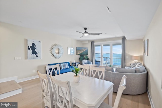 dining space with ceiling fan and light hardwood / wood-style floors