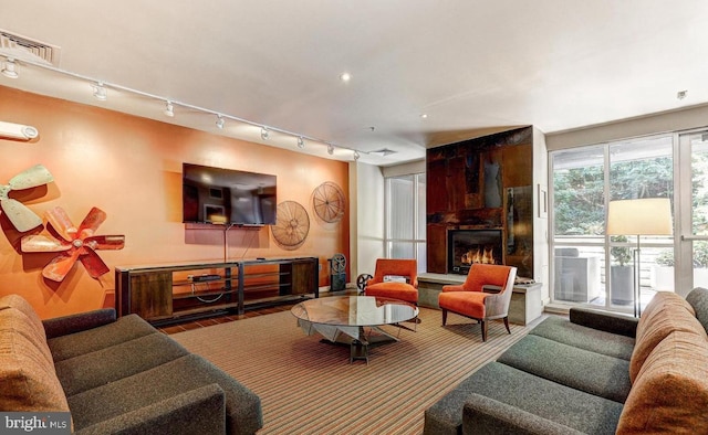 living room with a large fireplace and rail lighting