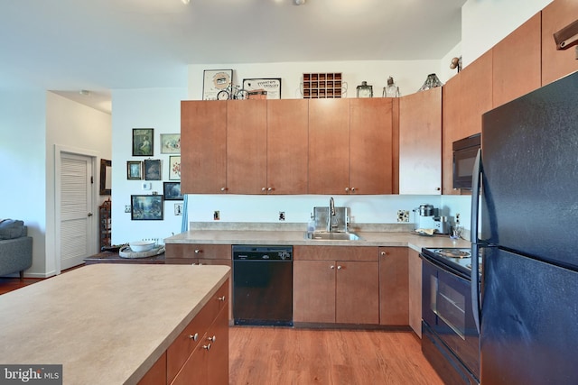 kitchen with sink, light wood-type flooring, and black appliances