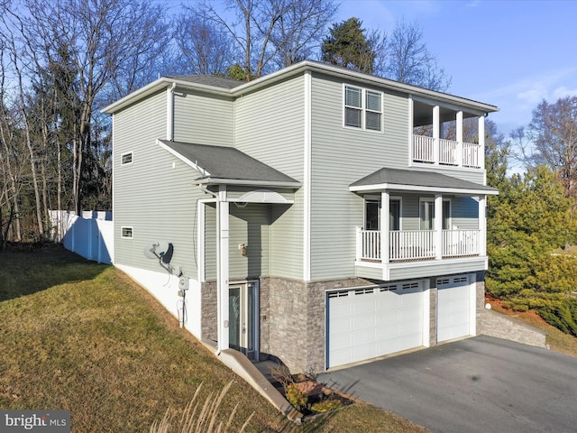 view of front of home with a garage, a balcony, and a front lawn