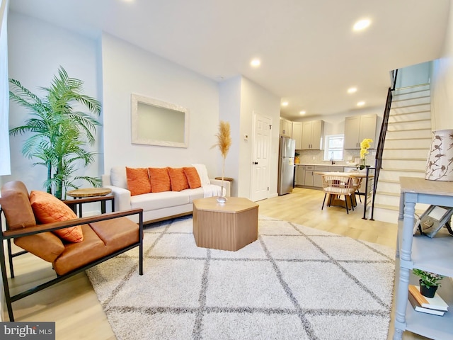 living room featuring light wood-type flooring and sink