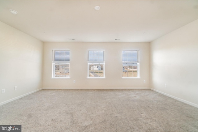 spare room featuring light colored carpet