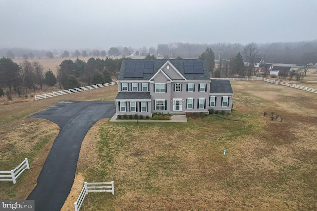 view of front of home featuring a front lawn and solar panels