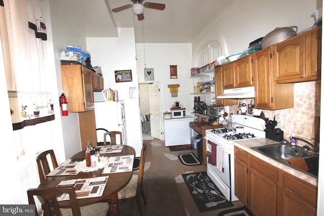 kitchen with white appliances, washer / clothes dryer, ceiling fan, and sink