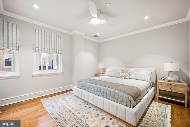 bedroom featuring ceiling fan, ornamental molding, and wood-type flooring