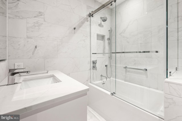 bathroom with vanity, enclosed tub / shower combo, and tile walls