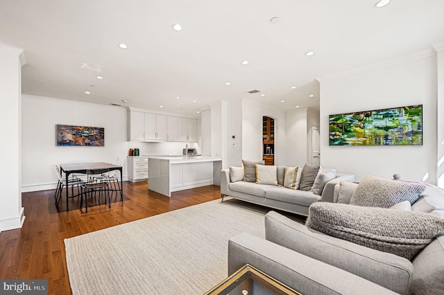 living room with dark wood-type flooring and ornamental molding