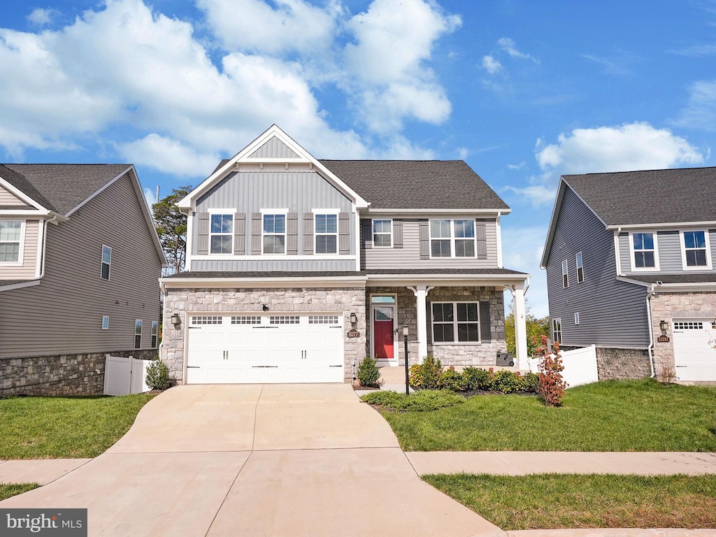 craftsman inspired home featuring a garage and a front lawn