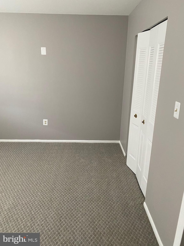 spare room with dark colored carpet