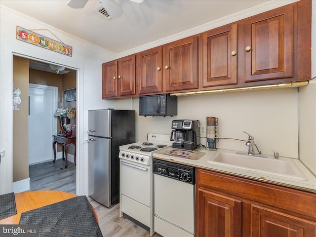 kitchen with white appliances, light hardwood / wood-style floors, ornamental molding, and sink