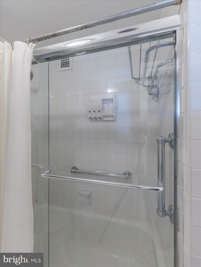 bathroom with shower / bath combination with glass door