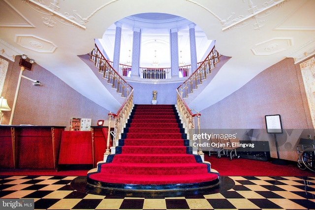 stairs featuring ornate columns and crown molding